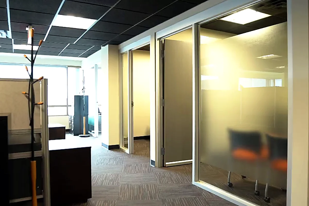 Corridor du 4e étage bordé de bureaux à cloisons vitrées