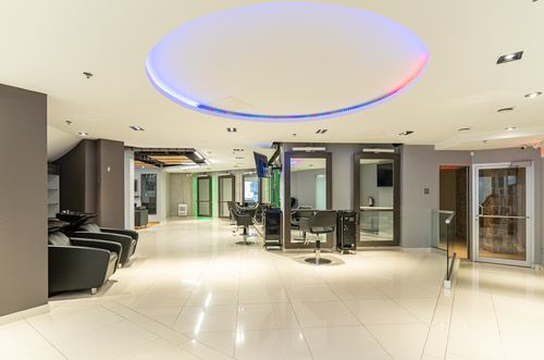 Full salon floor with the signature circular LED ceiling feature and polished tile