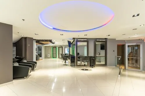 Full salon floor with the signature circular LED ceiling feature and polished tile