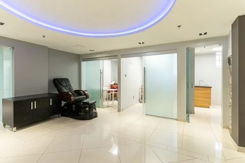 Private treatment rooms with pedicure spa chair under an LED accent ceiling