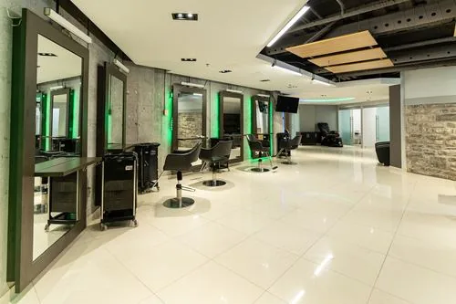 Styling stations with backlit mirrors set against a concrete feature wall